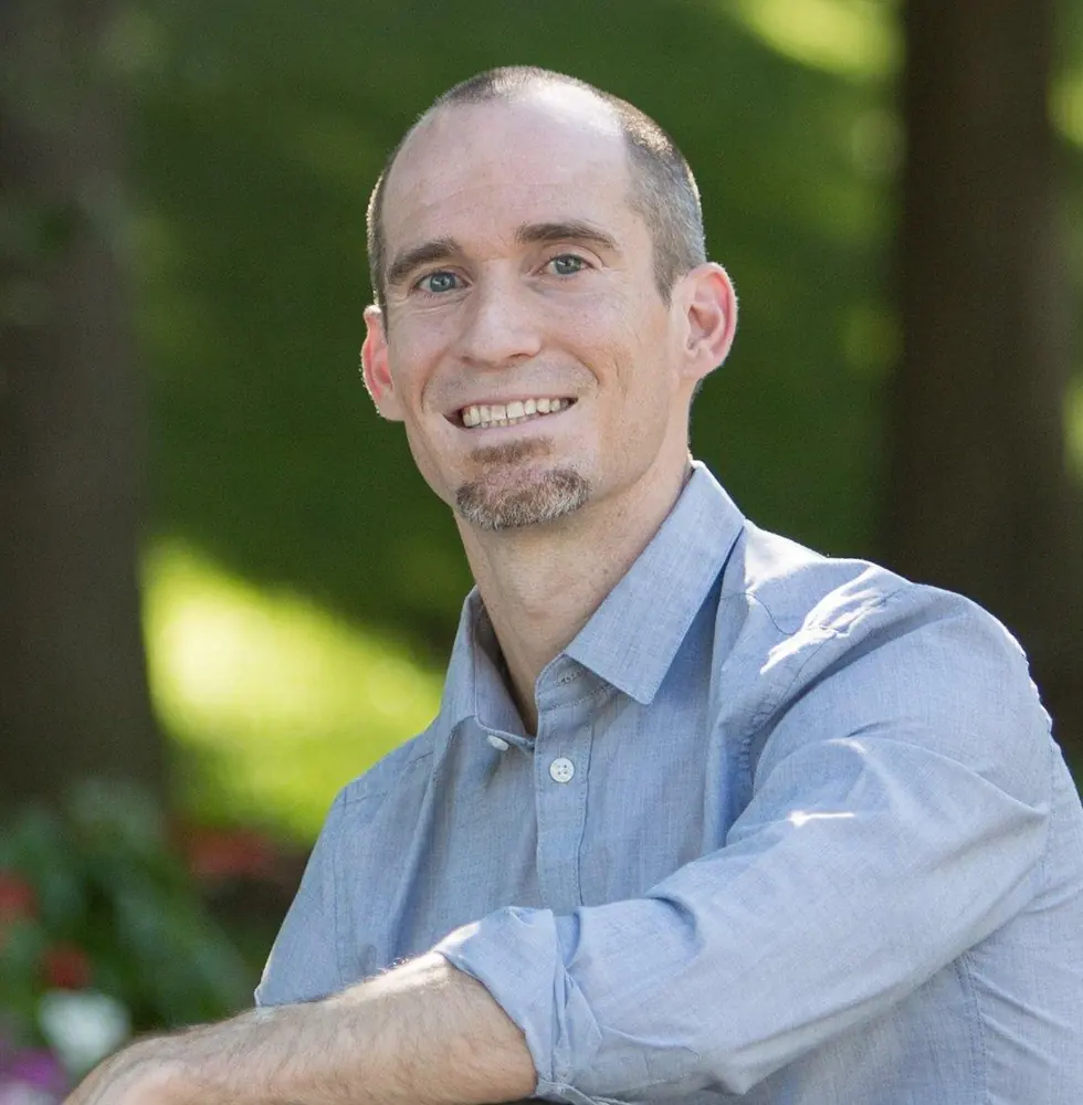 Dr. Jared Seigler smiling outdoors in a light blue shirt